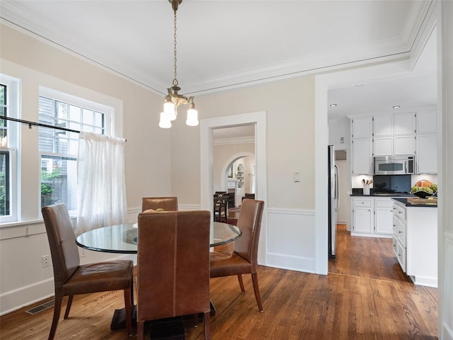 dining room with ornamental molding, dark wood finished floors, and visible vents