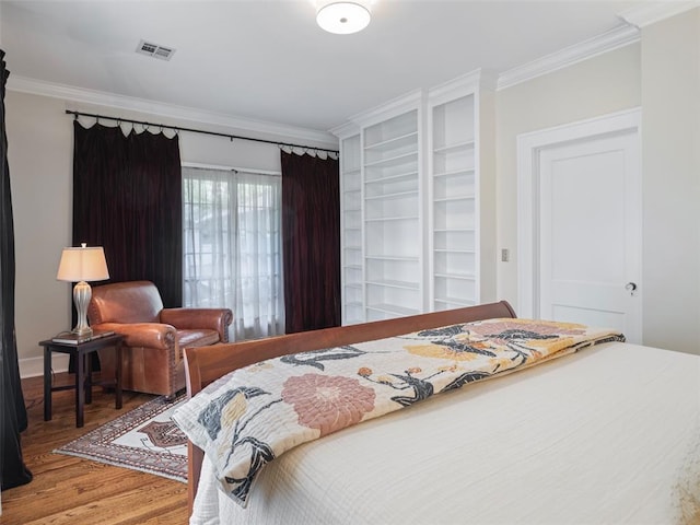 bedroom featuring visible vents, ornamental molding, and light wood-type flooring