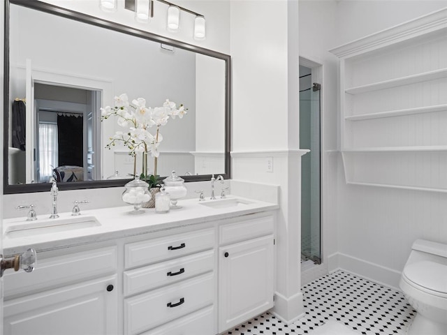 bathroom with a sink, a stall shower, toilet, and double vanity
