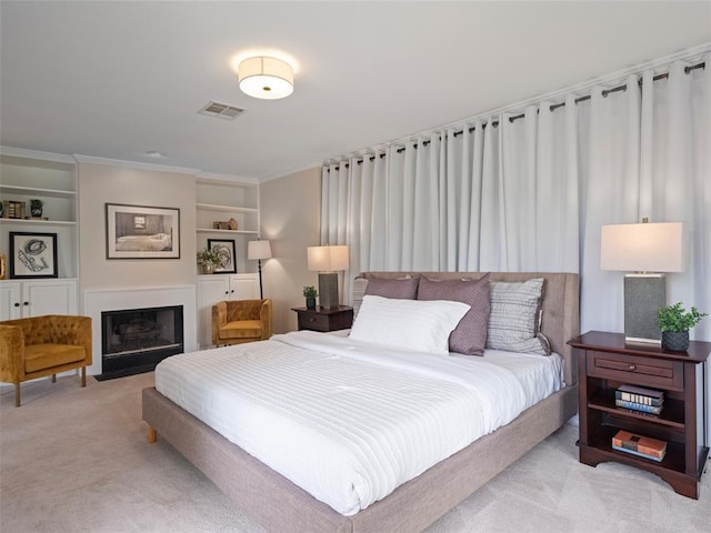 carpeted bedroom featuring a fireplace with flush hearth, ornamental molding, and visible vents