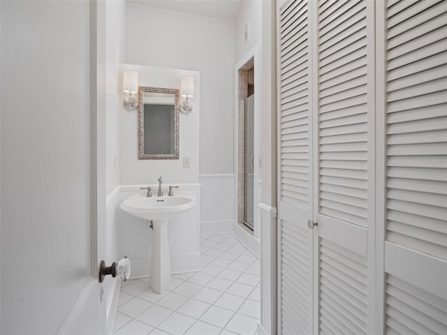 bathroom with tile patterned flooring, a sink, a closet, and a shower stall
