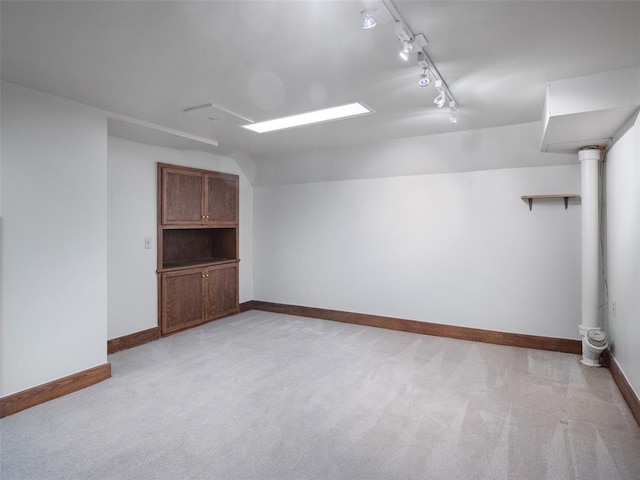 interior space featuring baseboards, light colored carpet, and track lighting