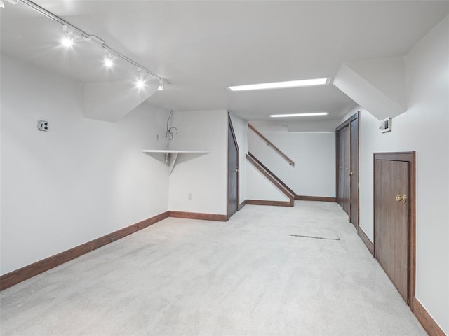 additional living space with stairway, baseboards, and light colored carpet