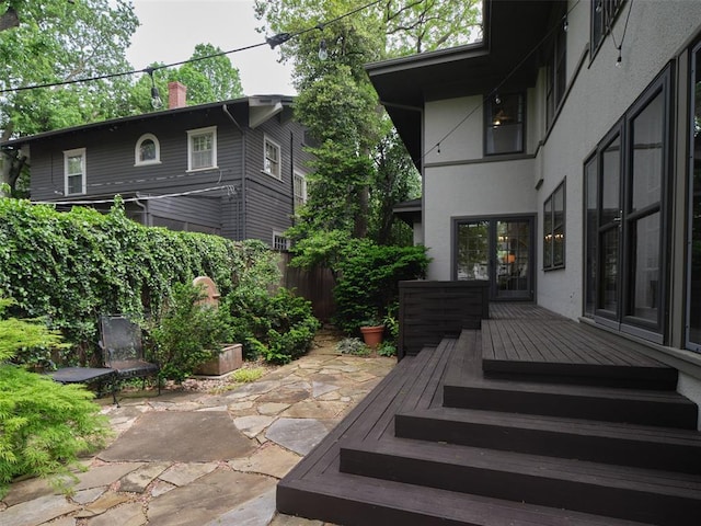 view of patio featuring fence and a wooden deck