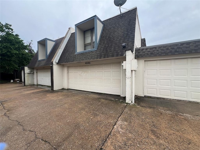 view of property exterior with driveway and roof with shingles