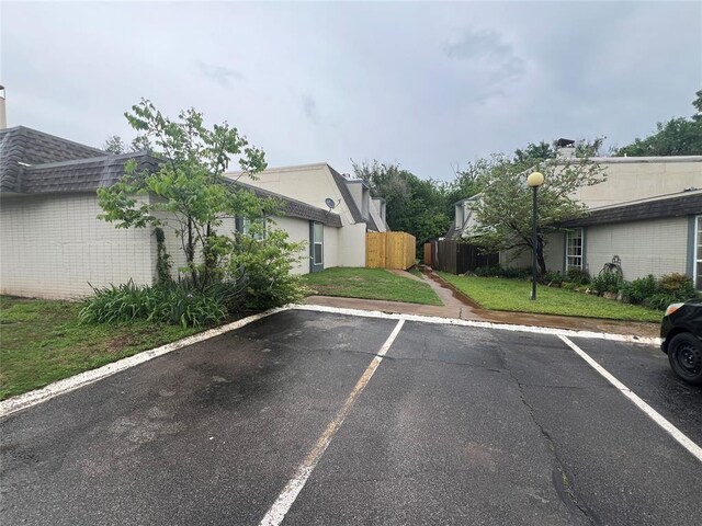 uncovered parking lot featuring fence