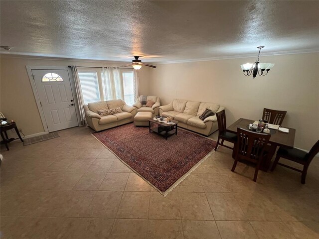 living room with crown molding, a textured ceiling, ceiling fan with notable chandelier, and light tile patterned floors