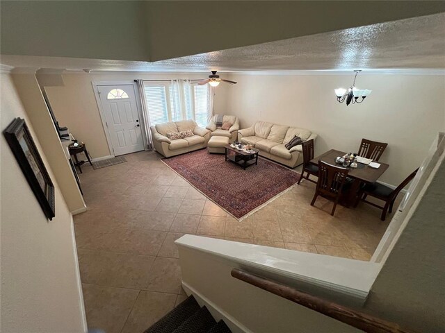 living area with a textured ceiling, tile patterned flooring, and ceiling fan with notable chandelier