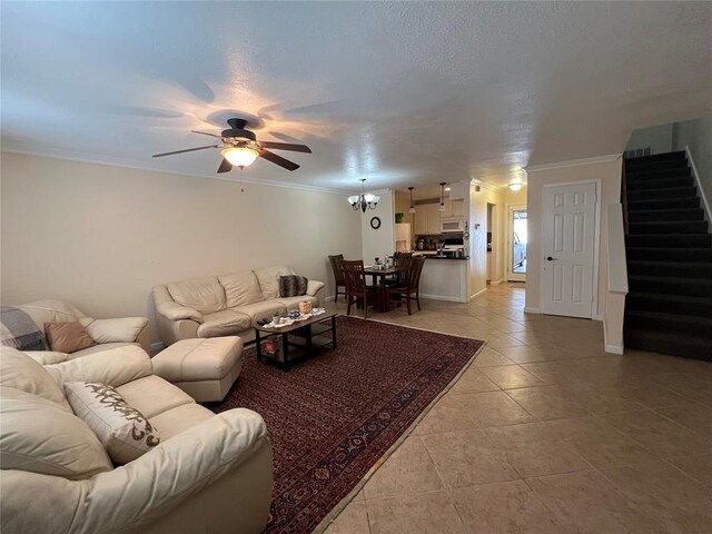 living area with crown molding, ceiling fan, light tile patterned floors, and stairway