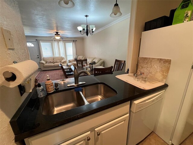 kitchen with dark countertops, open floor plan, a sink, dishwasher, and hanging light fixtures
