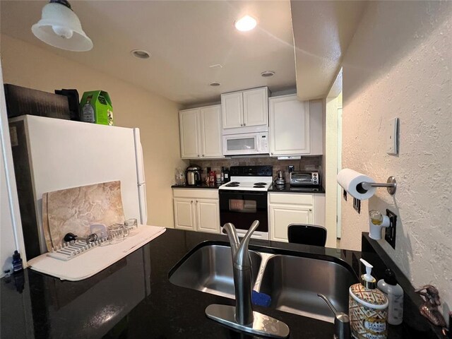 kitchen with decorative backsplash, dark countertops, white appliances, white cabinetry, and a sink