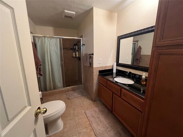 full bath featuring tile patterned flooring, vanity, toilet, visible vents, and a stall shower