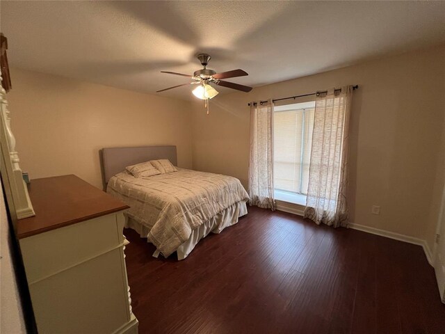 bedroom featuring a ceiling fan, baseboards, and dark wood-style floors