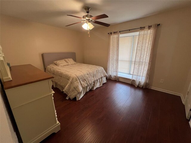 bedroom featuring baseboards, ceiling fan, and dark wood-type flooring