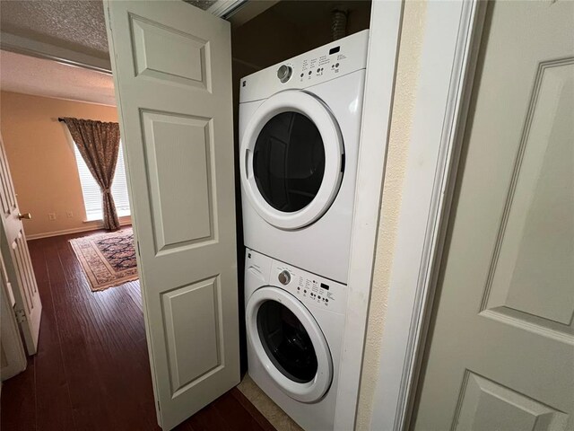 washroom with laundry area, baseboards, stacked washing maching and dryer, and dark wood-style floors