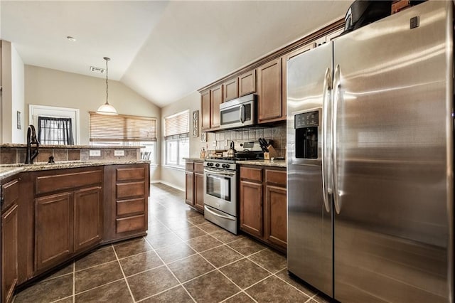 kitchen featuring decorative backsplash, dark tile patterned flooring, a sink, appliances with stainless steel finishes, and vaulted ceiling
