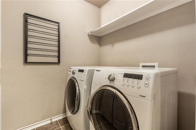 laundry area featuring laundry area, baseboards, separate washer and dryer, and dark tile patterned floors