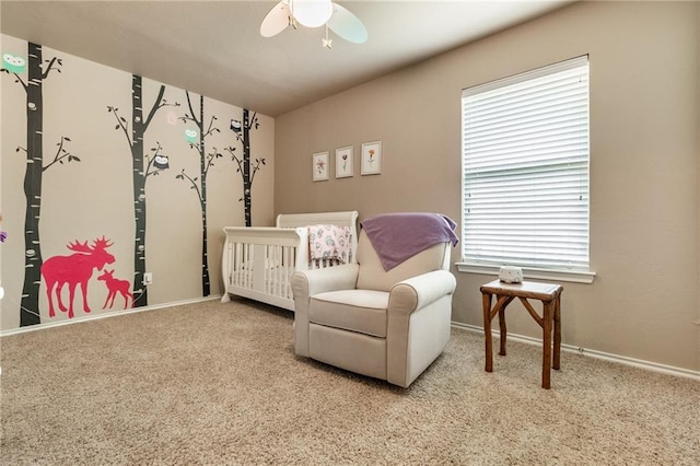 bedroom with baseboards, ceiling fan, carpet, and a nursery area