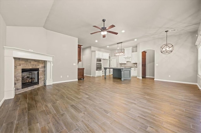 1016 NW 191st St, Edmond, OK 73012 - unfurnished living room with a fireplace, ceiling fan with notable chandelier, recessed lighting, baseboards, and wood finished floors