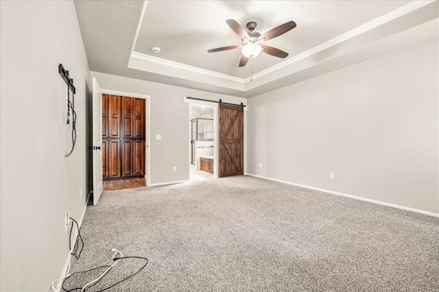 1016 NW 191st St, Edmond, OK 73012 - unfurnished bedroom featuring light carpet, a barn door, ensuite bath, baseboards, and a tray ceiling