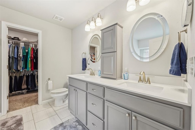 9104 SW 47th St, Oklahoma City, OK 73179 - bathroom with double vanity, toilet, visible vents, and a sink