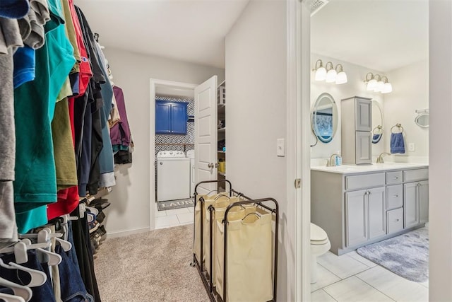 9104 SW 47th St, Oklahoma City, OK 73179 - spacious closet featuring light tile patterned floors, separate washer and dryer, and a sink