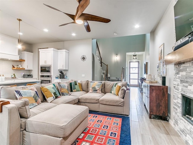 living room featuring a ceiling fan, recessed lighting, stairway, and light wood-type flooring