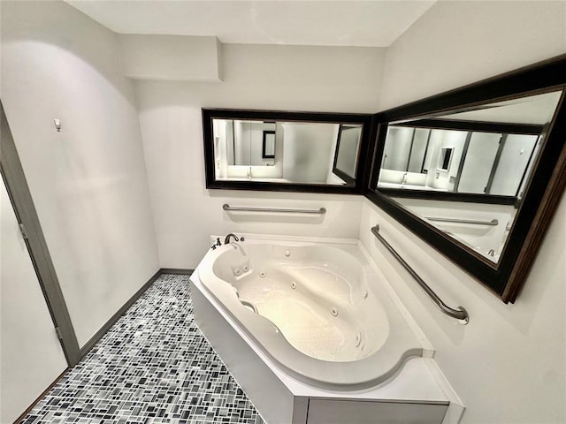 bathroom featuring baseboards, tile patterned flooring, and a whirlpool tub