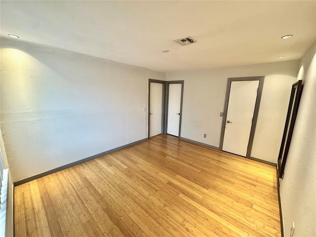 unfurnished room featuring visible vents, light wood-style flooring, baseboards, and recessed lighting