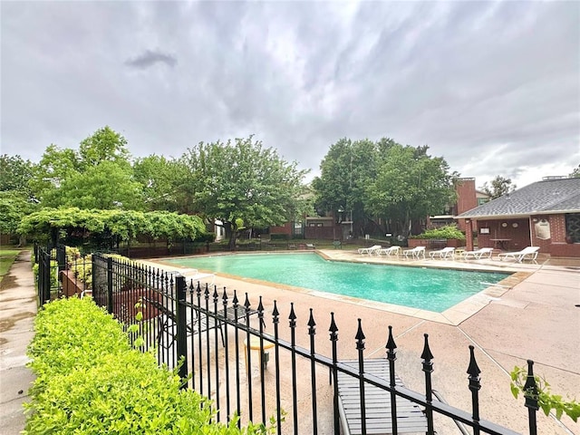 community pool featuring a patio area and fence