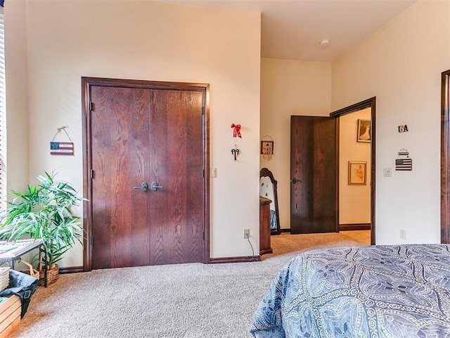 carpeted bedroom featuring baseboards and a closet