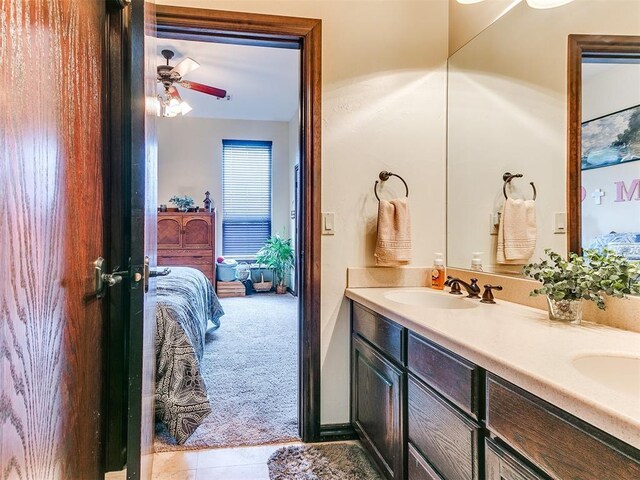 full bath with double vanity, a ceiling fan, tile patterned flooring, a sink, and ensuite bathroom