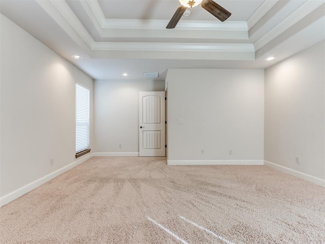 carpeted empty room featuring crown molding, a raised ceiling, baseboards, and recessed lighting
