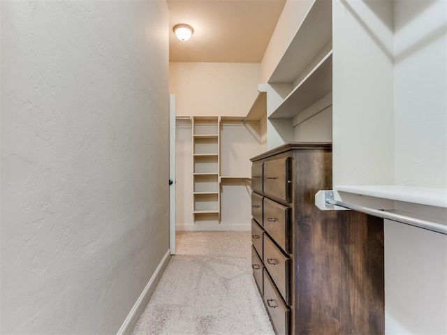 walk in closet with light carpet