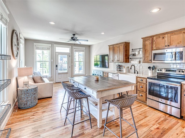 34 Boardwalk Unit B, Carlton Landing, OK 74432 - kitchen with light countertops, light wood finished floors, brown cabinets, and stainless steel appliances