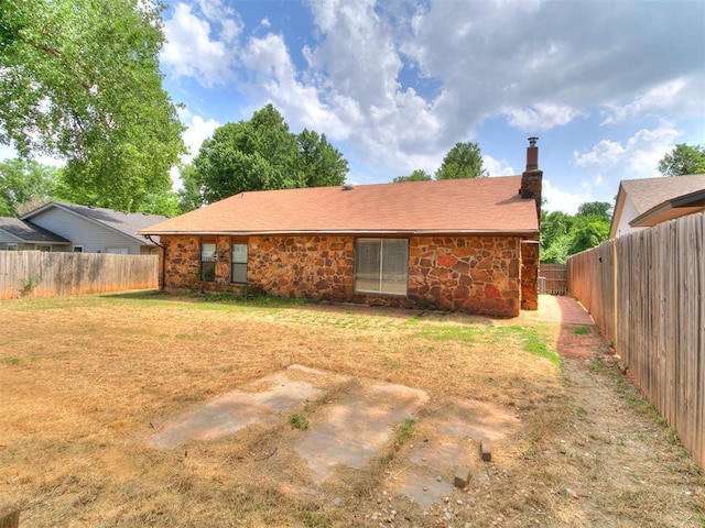 11817 Hollyrock Dr, Yukon, OK 73099 - rear view of house featuring stone siding and a chimney