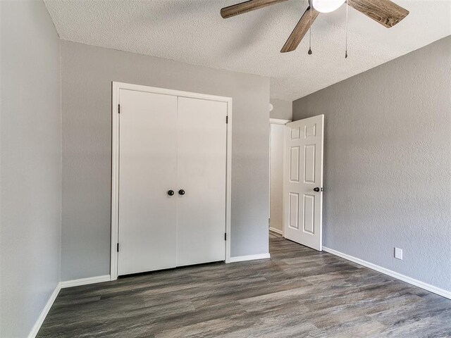 11817 Hollyrock Dr, Yukon, OK 73099 - unfurnished bedroom featuring wood finished floors, a textured ceiling, a closet, baseboards, and a ceiling fan