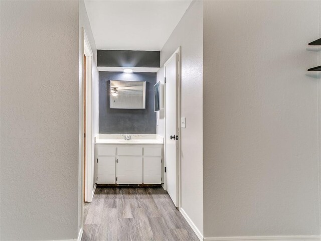 11817 Hollyrock Dr, Yukon, OK 73099 - hallway featuring wood finished floors, baseboards, a sink, and a textured wall