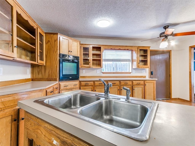 11817 Hollyrock Dr, Yukon, OK 73099 - kitchen with oven, a sink, light countertops, open shelves, and a textured ceiling