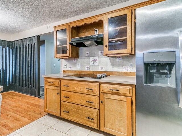 11817 Hollyrock Dr, Yukon, OK 73099 - kitchen with stainless steel fridge, under cabinet range hood, light countertops, black electric stovetop, and light tile patterned floors