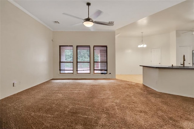8713 Starling Path, Edmond, OK 73034 - unfurnished living room featuring ceiling fan, light colored carpet, a chandelier, and ornamental molding