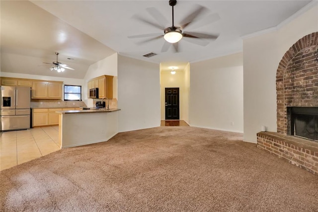 8713 Starling Path, Edmond, OK 73034 - unfurnished living room featuring ceiling fan, a fireplace, light carpet, vaulted ceiling, and ornamental molding