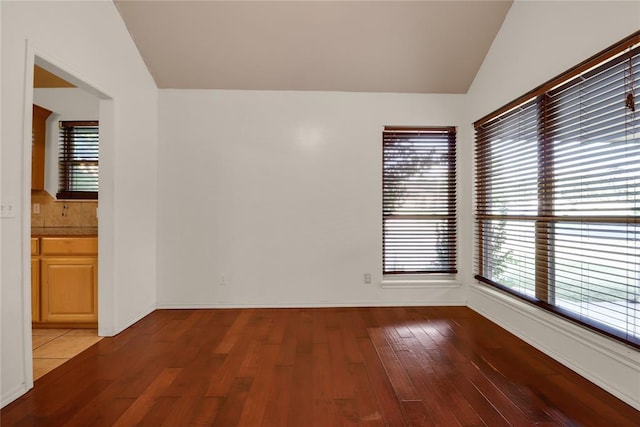 8713 Starling Path, Edmond, OK 73034 - empty room with vaulted ceiling, light wood finished floors, and baseboards