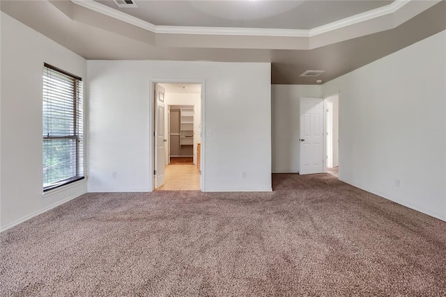 8713 Starling Path, Edmond, OK 73034 - unfurnished bedroom featuring crown molding, light colored carpet, baseboards, a tray ceiling, and a walk in closet