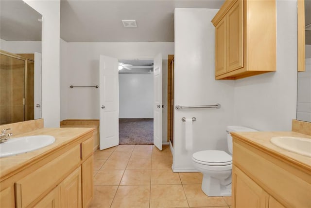 8713 Starling Path, Edmond, OK 73034 - bathroom featuring two vanities, a stall shower, tile patterned flooring, and toilet