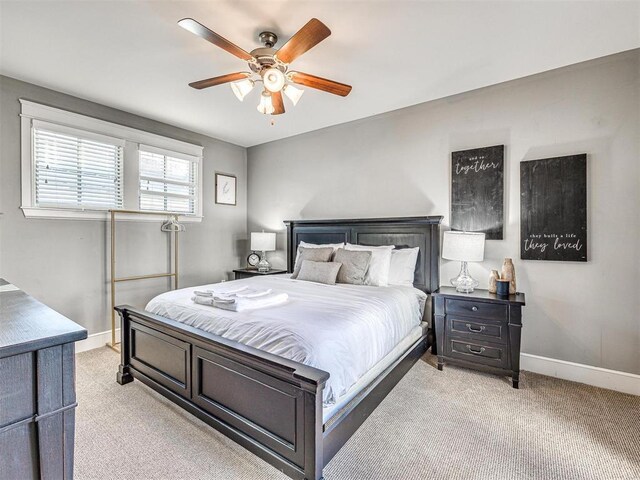 bedroom with baseboards, ceiling fan, and light carpet