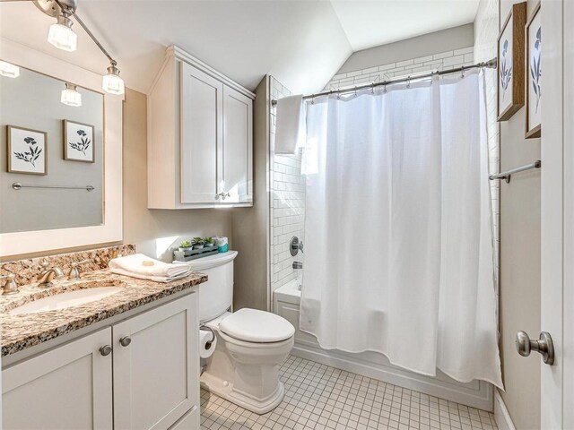 bathroom featuring tile patterned flooring, vanity, toilet, vaulted ceiling, and shower / tub combo