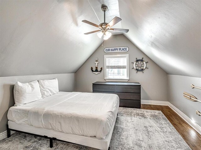 bedroom featuring baseboards, ceiling fan, wood finished floors, and lofted ceiling