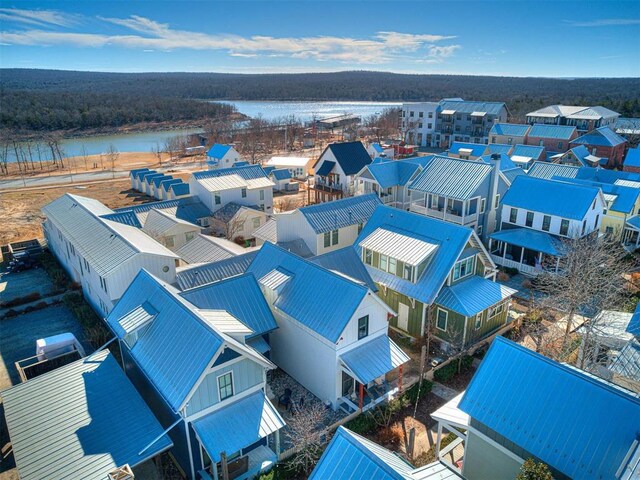 drone / aerial view with a water view and a forest view