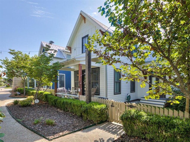view of front of home featuring fence and covered porch